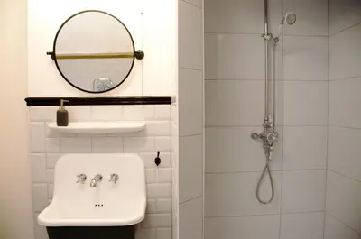 a bathroom with a sink and a mirror and a shower at Wellington House Boutique Holiday Let in Falmouth