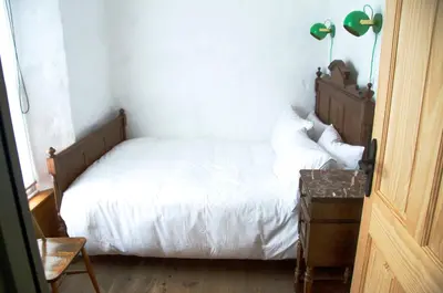 a bedroom with a white bed with a wooden headboard at Wellington House Boutique Holiday Let in Falmouth