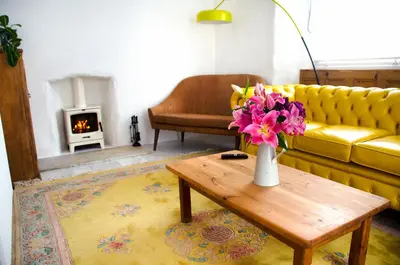 a living room with a couch and a table with flowers at Wellington House Boutique Holiday Let in Falmouth