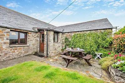 a stone cottage with a picnic table in the yard at 2 Bed in St. Merryn oc-w29716 in St Merryn