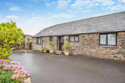 a brick house with potted plants in front of it at 2 Bed in Padstow oc-w3658 in St Merryn