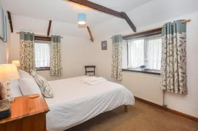 a bedroom with a white bed and two windows at 2 Bed in Padstow oc-w3658 in St Merryn