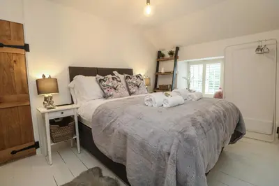 a bedroom with a large bed with towels on it at Bumblebee Cottage in Bodmin