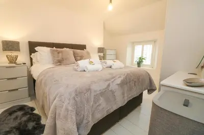 a bedroom with a large bed with towels on it at Bumblebee Cottage in Bodmin