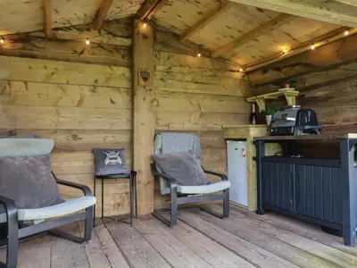 two chairs and a counter in a wooden cabin at Bumblebee Cottage in Bodmin