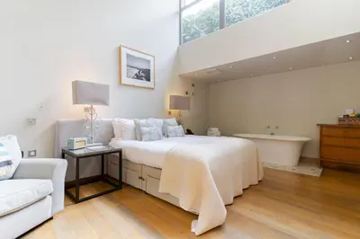a bedroom with a large bed and a bath tub at Prospect House in Padstow