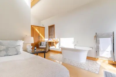 a bedroom with a bed and a bath tub in it at Prospect House in Padstow