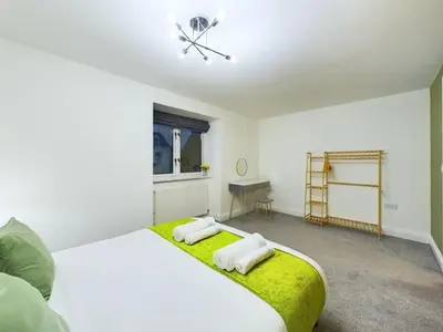 a bedroom with a large bed with two towels on it at Bredon Court by Signature Stays - Modern - Beach - Parking in Newquay