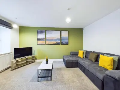 a living room with a couch and a flat screen tv at Bredon Court by Signature Stays - Modern - Beach - Parking in Newquay