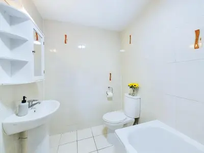 a white bathroom with a toilet and a sink at Bredon Court by Signature Stays - Modern - Beach - Parking in Newquay