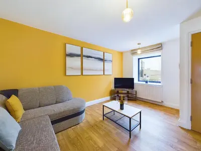 a living room with a couch and a tv at Newquay Beach House by Signature Stays - Parking - Modern - Coastal in Newquay