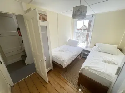 a small room with two beds and a window at Mermaids Rest in St Ives