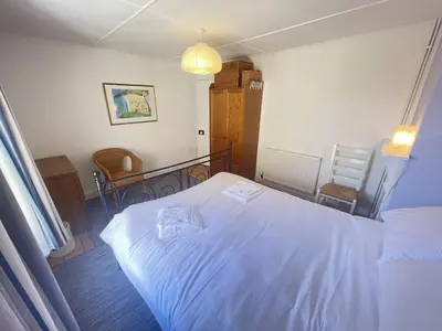 a bedroom with a white bed in a room at Mermaids Rest in St Ives
