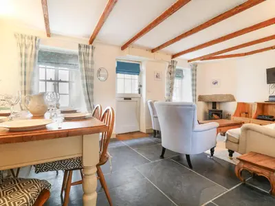 a dining room with a table and chairs and a living room at Aunt Dora's in Port Isaac