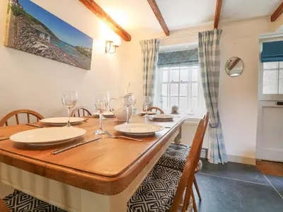 a dining room with a wooden table and chairs at Aunt Dora's in Port Isaac