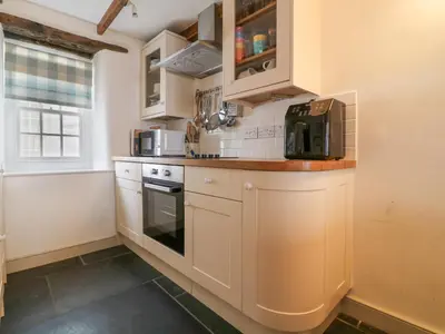 a kitchen with white cabinets and a stove top oven at Aunt Dora's in Port Isaac