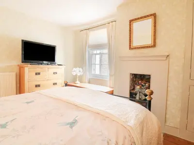 a bedroom with a bed with a tv and a fireplace at Aunt Dora's in Port Isaac
