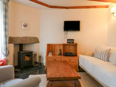 a living room with a couch and a fireplace at Aunt Dora's in Port Isaac