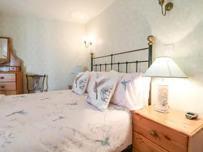 a bedroom with a bed and a lamp on a dresser at Aunt Dora's in Port Isaac