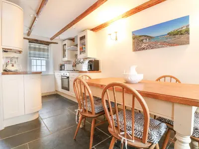 a kitchen and dining room with a wooden table and chairs at Aunt Dora's in Port Isaac