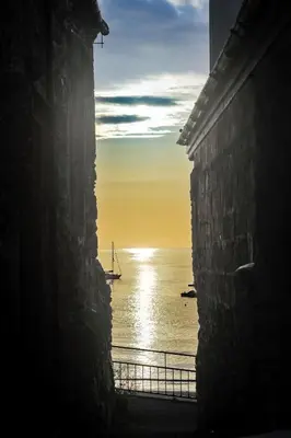 a view of the ocean with a sail boat in the water at Seaforth - Fisherman's Cottage in Gorran Haven