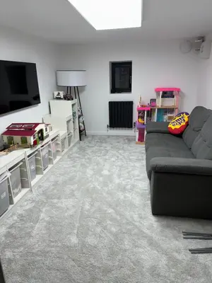a living room with a couch and a flat screen tv at Art Deco 52 in Truro