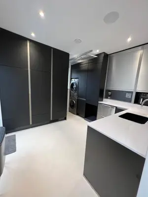 a kitchen with black cabinets and a washer and dryer at Art Deco 52 in Truro