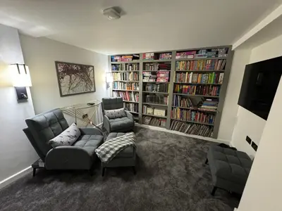 a living room with two couches and book shelves with books at Art Deco 52 in Truro
