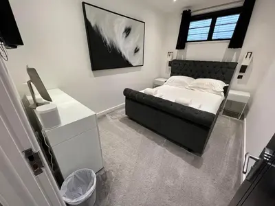 a bedroom with a bed with a black headboard at Art Deco 52 in Truro