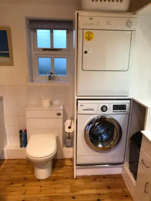 a bathroom with a washing machine and a toilet at The Nook in Padstow