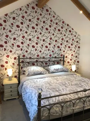 a bedroom with a bed with a floral wallpaper at The Nook in Padstow