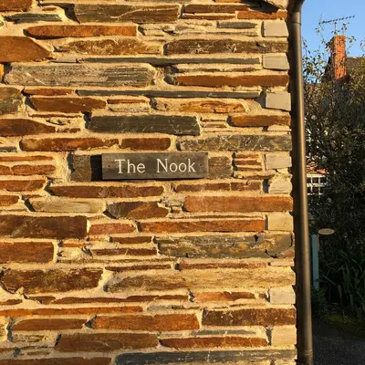 a sign on the side of a brick wall at The Nook in Padstow