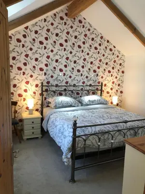 a bedroom with a bed with a floral patterned wall at The Nook in Padstow