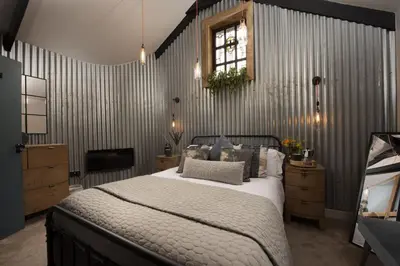 a bedroom with a large bed and a television at The Old Dairy in Camborne