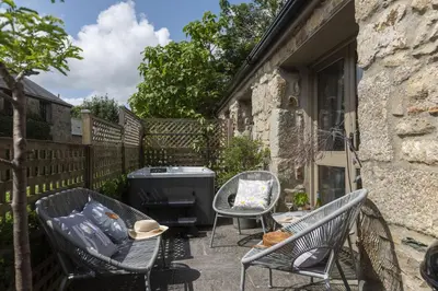 a patio with two chairs and a grill at The Old Dairy in Camborne
