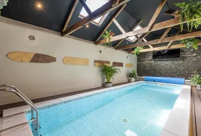 a swimming pool in a house with a ceiling at The Hay Loft in Camborne