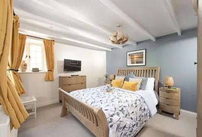 a bedroom with a bed and a television in a room at The Corner Cottage in Camborne