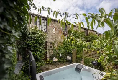 a bath tub in the yard of a building at The Corner Cottage in Camborne