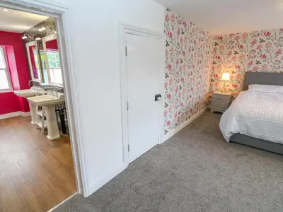 a bedroom with a bed and a bathroom with a sink at The Old Post Office in Camborne