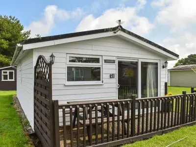a small white cottage with a wooden fence at Cat's Cove - Uk47720 in St Merryn