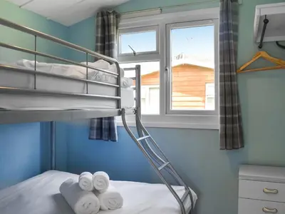 a bunk bed in a room with a window at Old Town Cove - Uk47724 in St Merryn