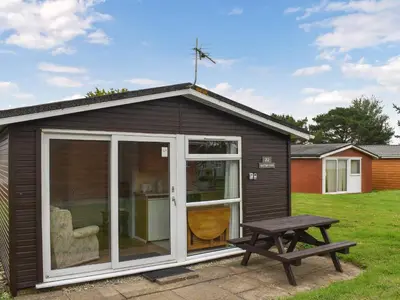 a small shed with a picnic table and a bench at Old Town Cove - Uk47724 in St Merryn
