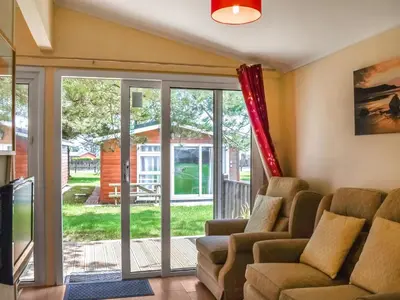 a living room with a couch and a sliding glass door at Harbour Cove - Uk47722 in St Merryn
