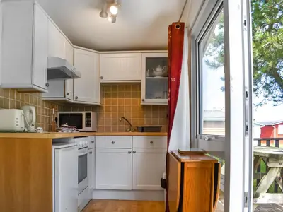 a kitchen with white cabinets and a window at Harbour Cove - Uk47722 in St Merryn