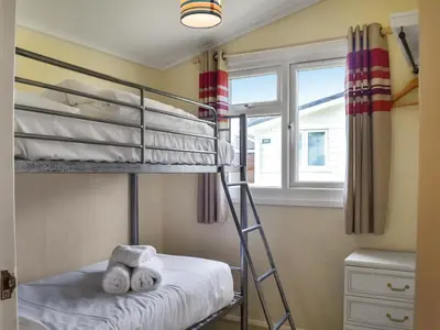 a bedroom with two bunk beds and a window at Harbour Cove - Uk47722 in St Merryn