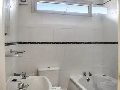 a bathroom with a sink and a toilet and a window at Harbour Cove - Uk47722 in St Merryn