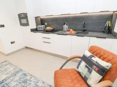 a kitchen with an orange chair and a counter at 2A Salubrious Terrace in St Ives