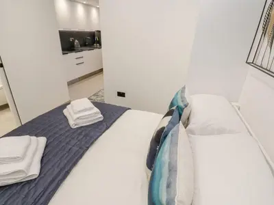 a bedroom with a white bed with towels on it at 2A Salubrious Terrace in St Ives