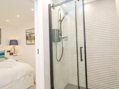 a shower with a glass door in a bedroom at 2A Salubrious Terrace in St Ives