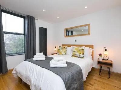 a bedroom with a large bed with towels on it at Nova Cottage in St Ives